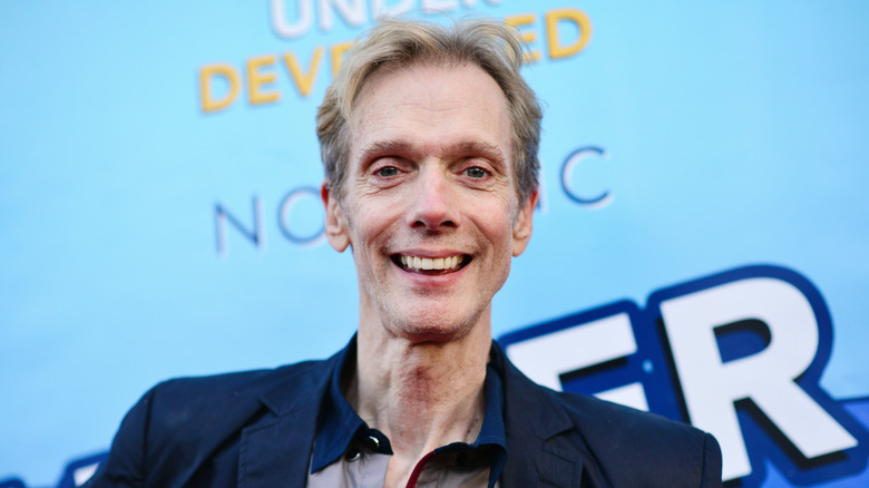 Doug Jones stands in front of a poster