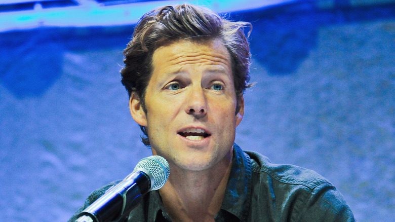 Jamie Bamber speaks into a microphone