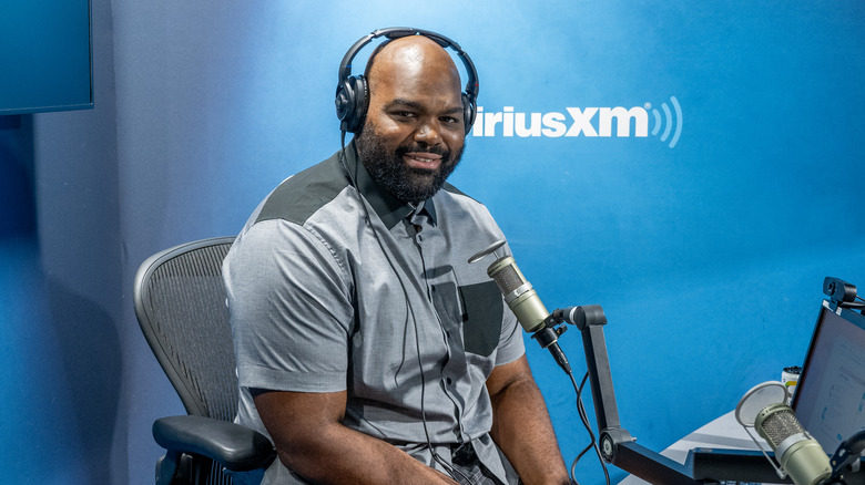 Michael Oher at desk with microphone