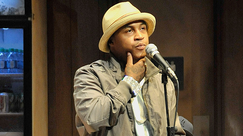 Orlando Brown speaking into a microphone and stroking his chin