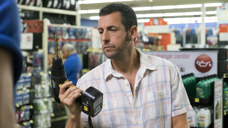 Adam Sandler holds drill