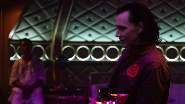 Tom Hiddleston as Loki drinking at a bar