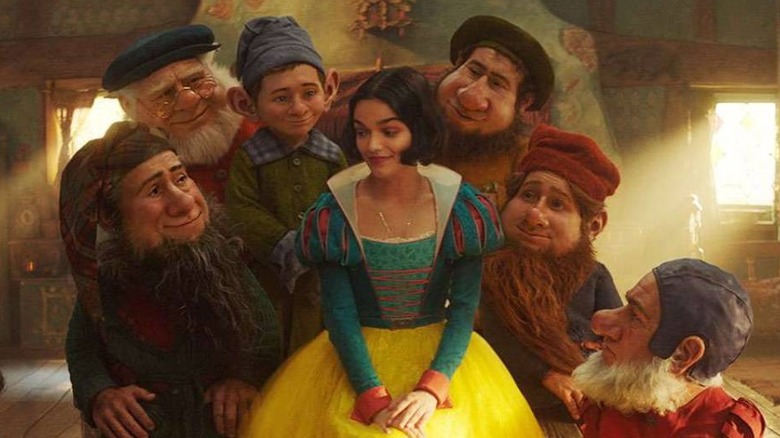 Snow White (Rachel Zegler) surrounded by the dwarfs in Snow White (2025)