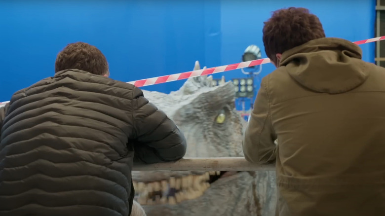 Crew looking at large Giganotosaurus robot