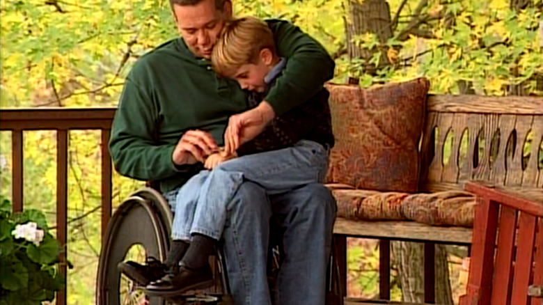 A father puts a bandaid on his son's hand