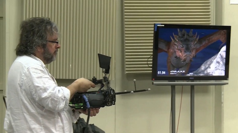 Peter Jackson holds motion capture camera with screen next to him showing what he's seeing