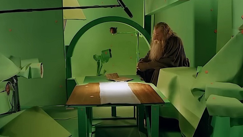 Ian McKellen sitting in a sea of green-covered props and equipment