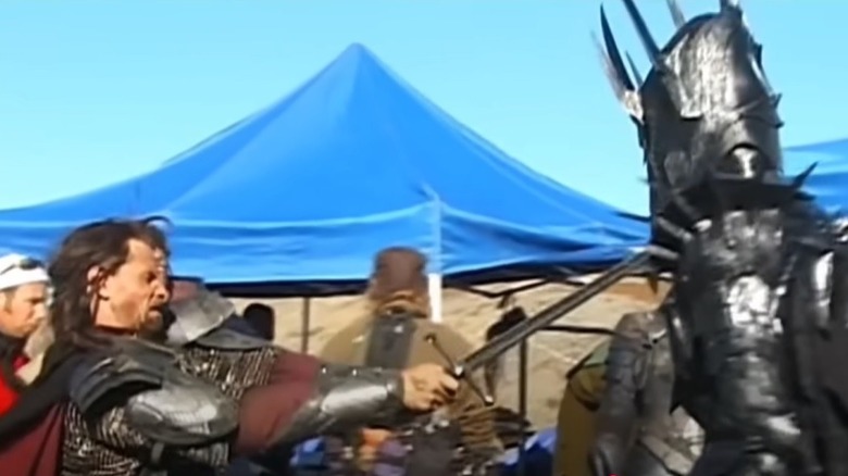 Aragorn and Sauron duel in front of the crew and blue tents