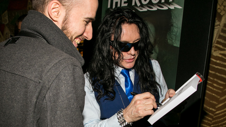 Tommy Wiseau signing autographs