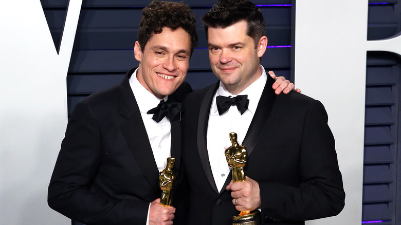 Phil Lord and Chris Miller smiling holding Oscars