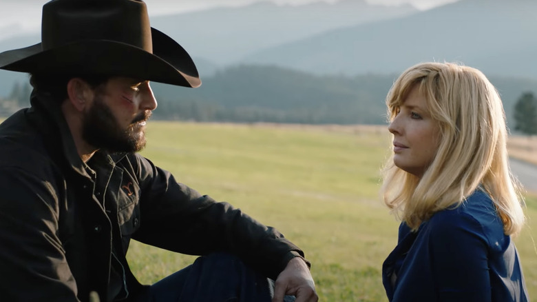 Kelly Reilly, Cole Hauser sitting in a field