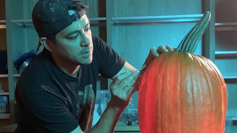 Chris Soria carves a pumpkin