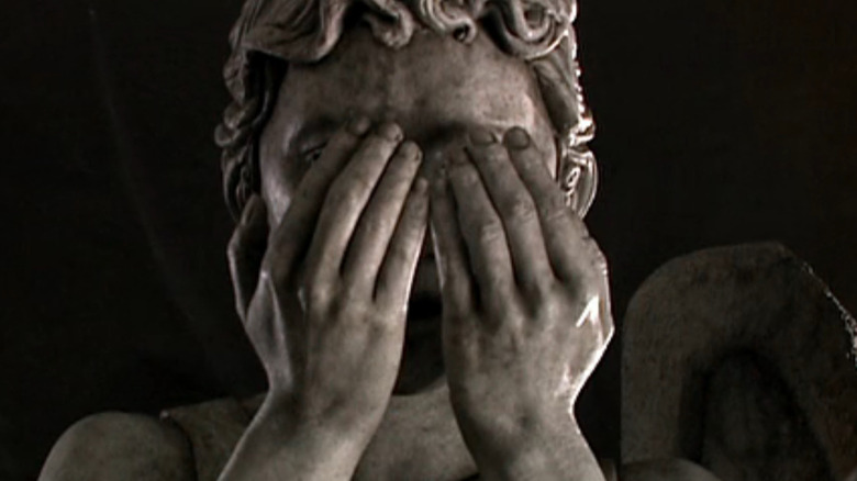 A Weeping Angel covers its face