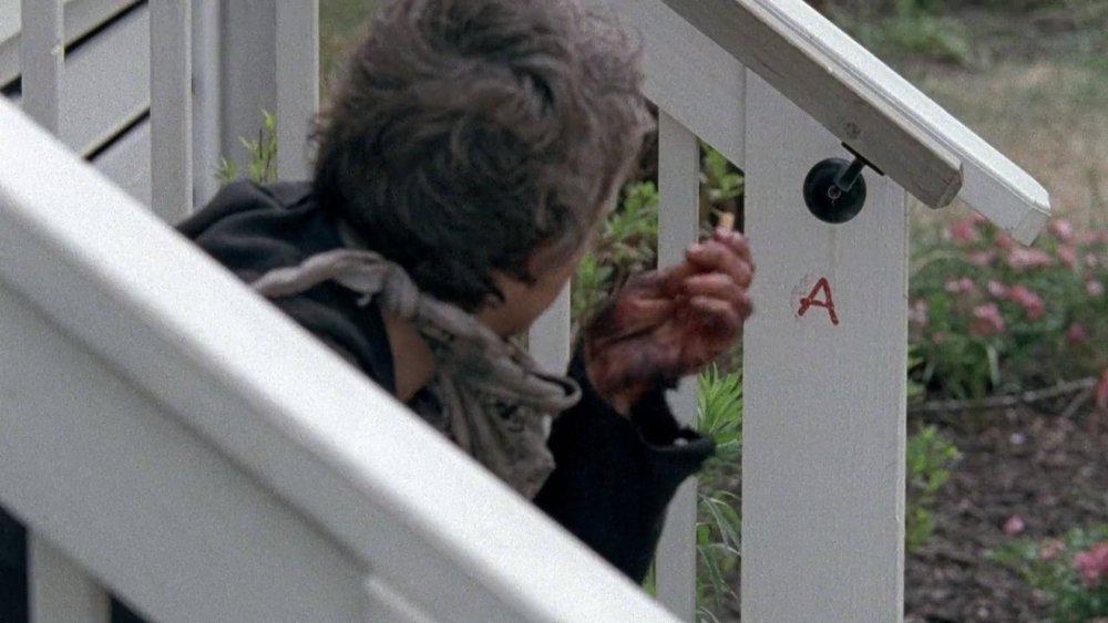 Carol looks at the letter "A" carved into the railing