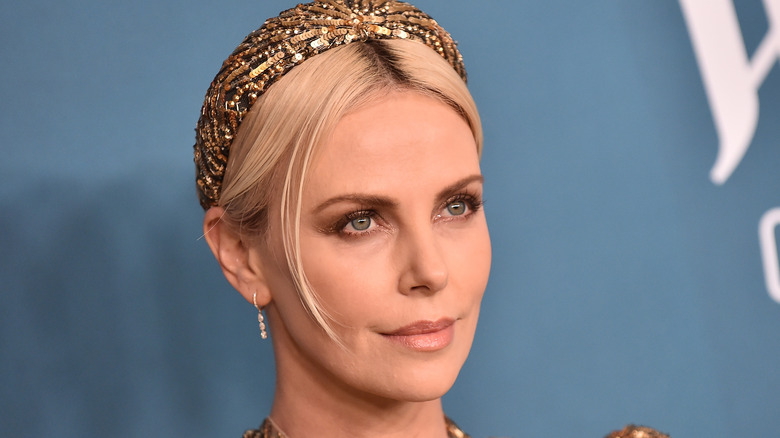 Charlize wearing gold headband on the red carpet