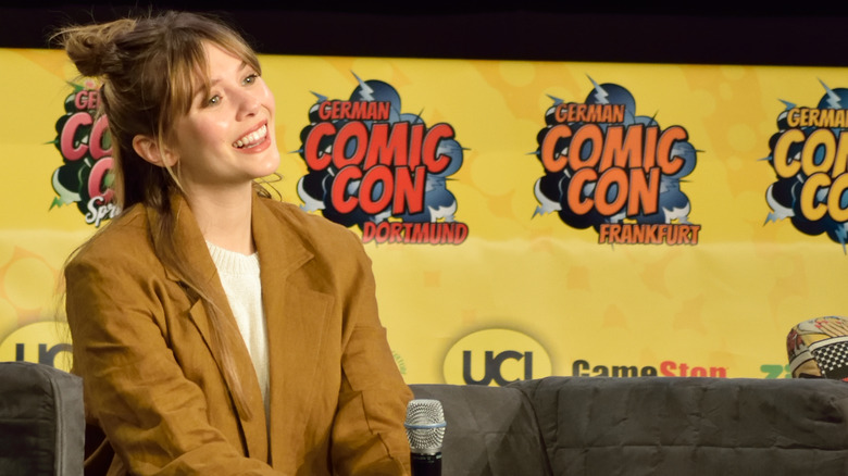 Olsen sitting on stage at German Comic Con