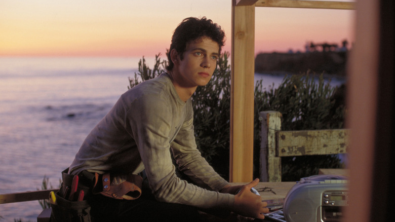 Sam sitting on a deck by the water