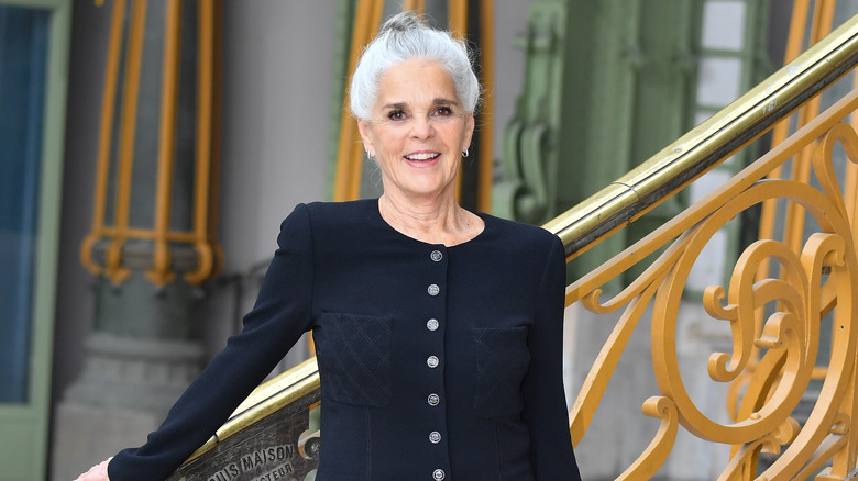 Ali MacGraw leans on a staircase