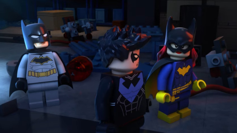 Batman, Nightwing, and Batgirl stand together