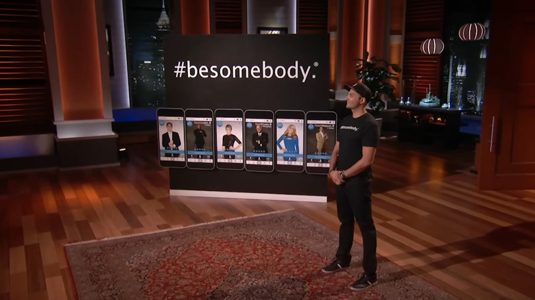 Kash Shaikh standing next to #besomebody display