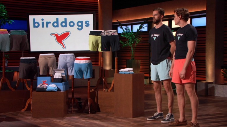 Chris Mason and Peter Baldwin beside a row of Birddogs merchandise 