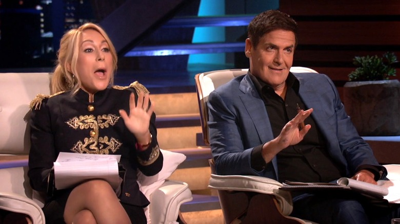 Lori Greiner and Mark Cuban holding up one hand