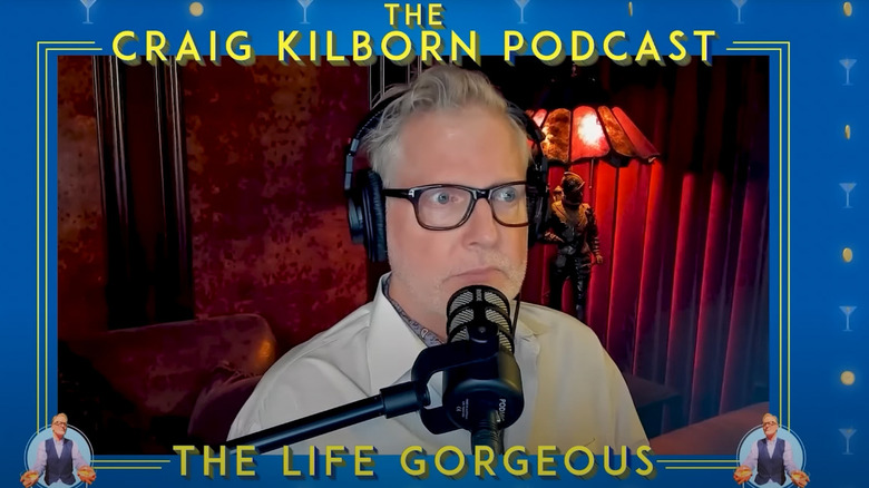 Craig Kilborn sits behind a microphone