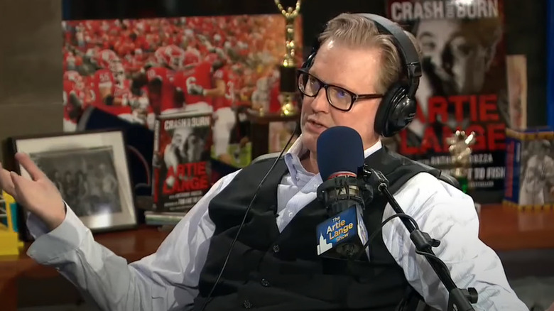 Craig Kilborn sits behind a microphone