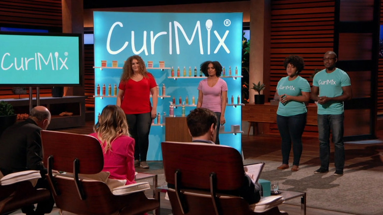 Kim and Tim presenting to sharks next to CurlMix display