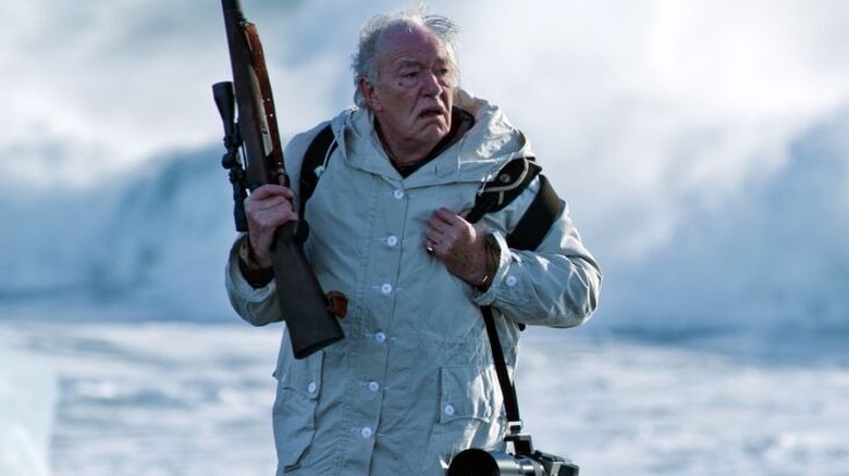 Henry Tyson with a gun and a camera on Fortitude