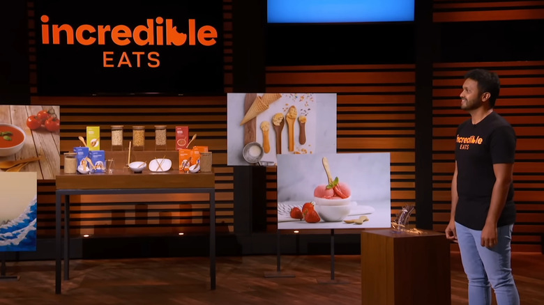 Dinesh standing next to IncrEdible Eats display on Shark Tank