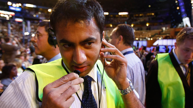 Kal Penn listening to headpiece 