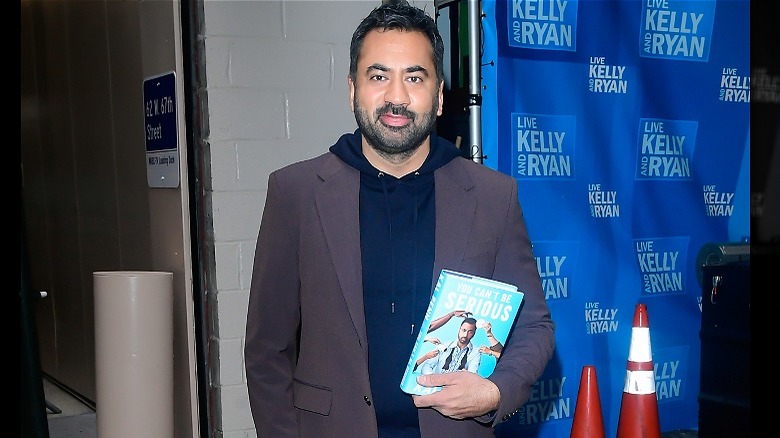 Kal Penn holding his memoir