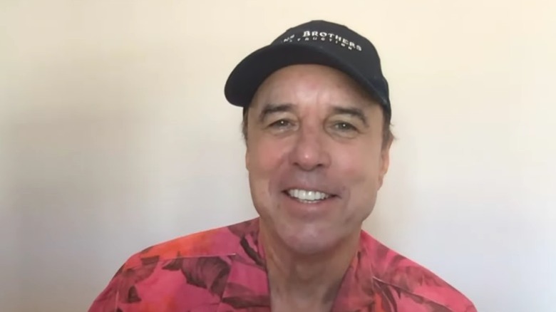 Kevin Nealon wearing a baseball cap