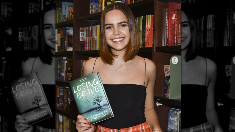 Bailee Madison smiling holding book