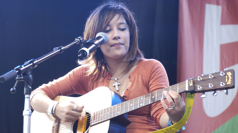 Lalaine singing and playing a guitar