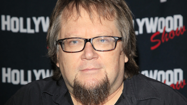 Robbie Rist poses at an event.