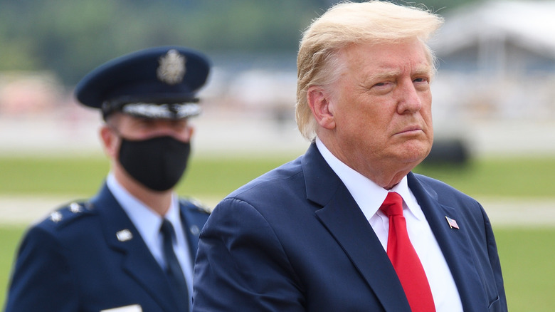 Donald Trump in front of masked air force soldier