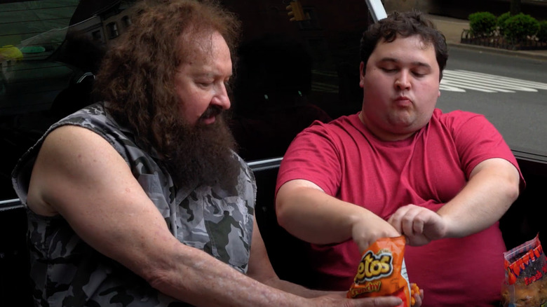 Randy Quaid eating Cheetos in pickup truck