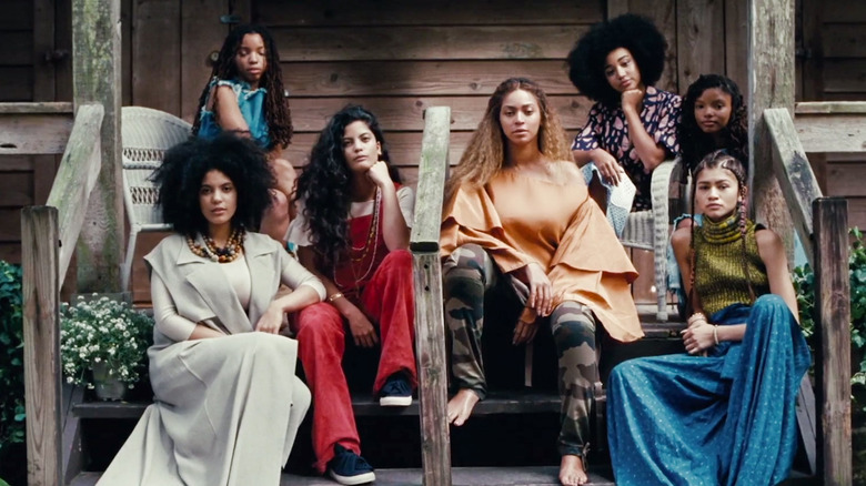 A group of women pose on porch steps