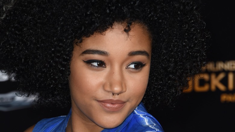 Amandla Stenberg in close-up smiling at a red carpet event