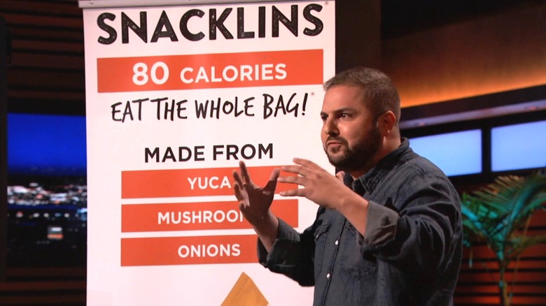 Sam next to a Snacklins display on Shark Tank