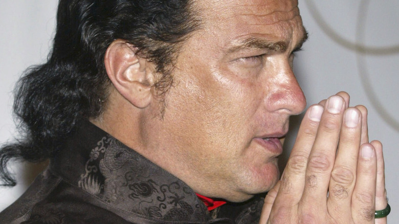 Steven Seagal with hands in front of face