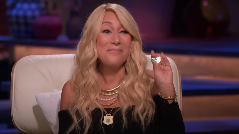 Lori Grenier smiling and holding golden ticket