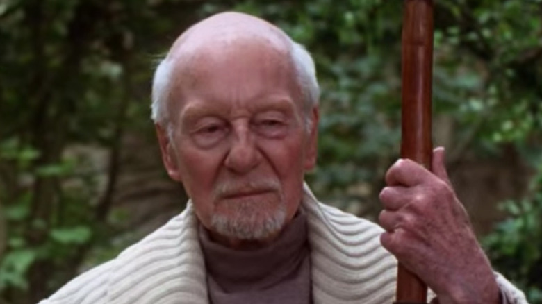 John Gielgud in white holds a staff