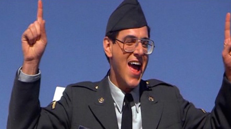 Harold Ramis smiles, fingers upraised