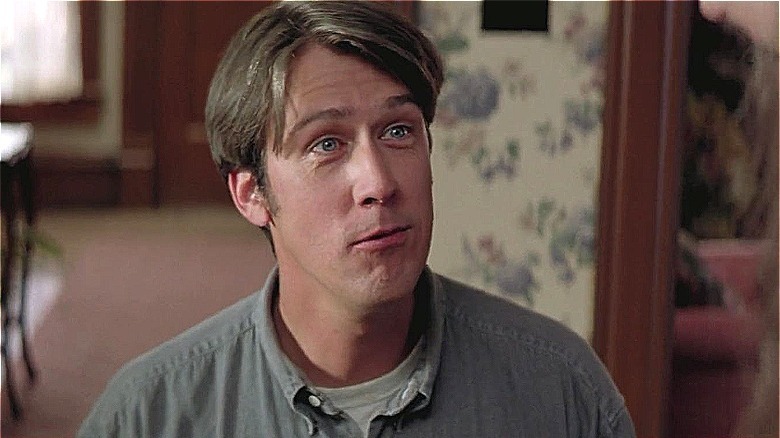 alan ruck in gray shirt, floral wallpaper in background