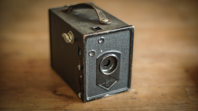 A vintage camera obscura on a wooden table