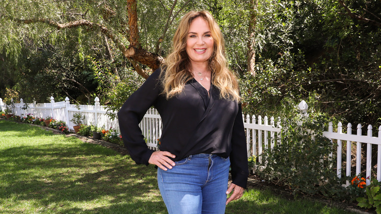 Catherine Bach smiles and stands with a hand on her hip