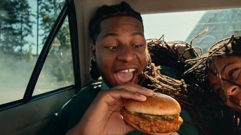 Man eating Wingstop chicken sandwich